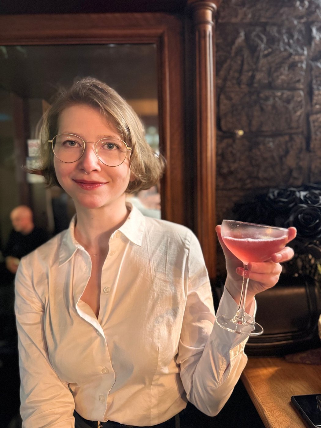 Agnes mit einem rosa Cocktail in der Hand